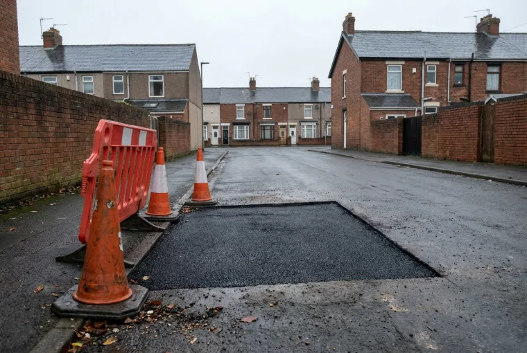 Interim reinstatement: a compacted tarmac patch over a backfilled trench making the road safe and trafficable