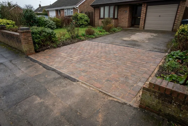 Permanent reinstatement: freshly re-laid block paving on a driveway, level and matched to the surrounding surface